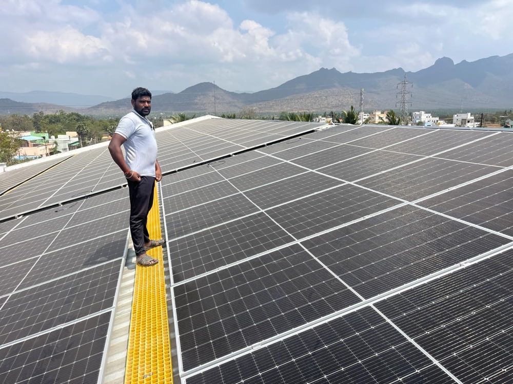 Technician on a completed rooftop solar installation